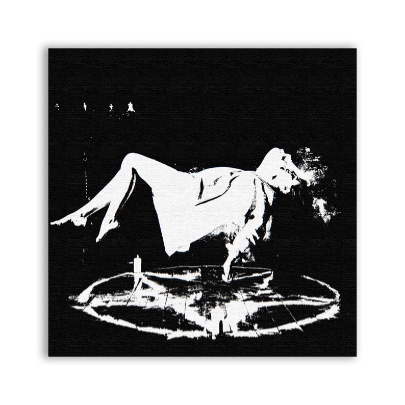 May include: A black and white image of a person levitating above a pentagram. The person is wearing a long, flowing robe and has their arms outstretched. The pentagram is drawn on the floor and there are candles around it.