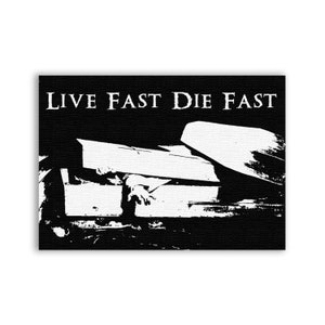 Könnte beinhalten: Schwarzweißes Bild eines Sarges mit dem Text "LIVE FAST DIE FAST" darüber.