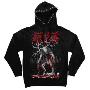 May include: A black hooded sweatshirt featuring a graphic print of a skeletal creature with antlers standing in a forest. The design includes red and white details, text at the top, and skulls at the base. The hood edge is lined with silver spikes.
