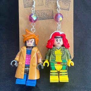 Pode incluir: Um par de brincos com minifiguras Lego dos personagens dos X-Men, Gambit e Rogue. Os brincos são prateados com contas iridescentes rosa e ganchos prateados.