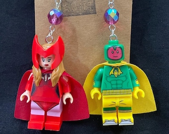 以下が含まれることがあります： スカーレット・ウィッチとヴィジョンのLEGOミニフィギュアが付いた、ぶら下がりのイヤリングのペア。イヤリングには虹色の紫色のビーズと銀色のフックが付いています。