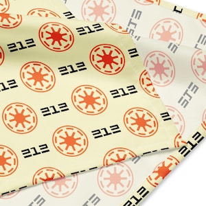 Puede incluir: Tela color crema con un patrón repetido de símbolos circulares naranjas y blancos y el número "212" en negro. La tela también presenta el texto "ETE" en negro.