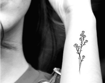 May include: A simple line drawing of a flower with multiple stems and leaves. The tattoo is on a person's arm.