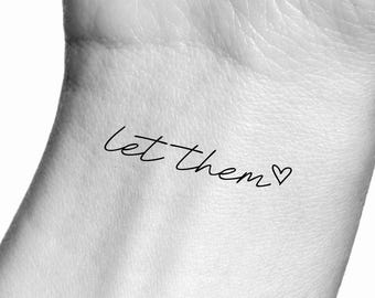 May include: A temporary tattoo with the text "let them" followed by a small heart.
