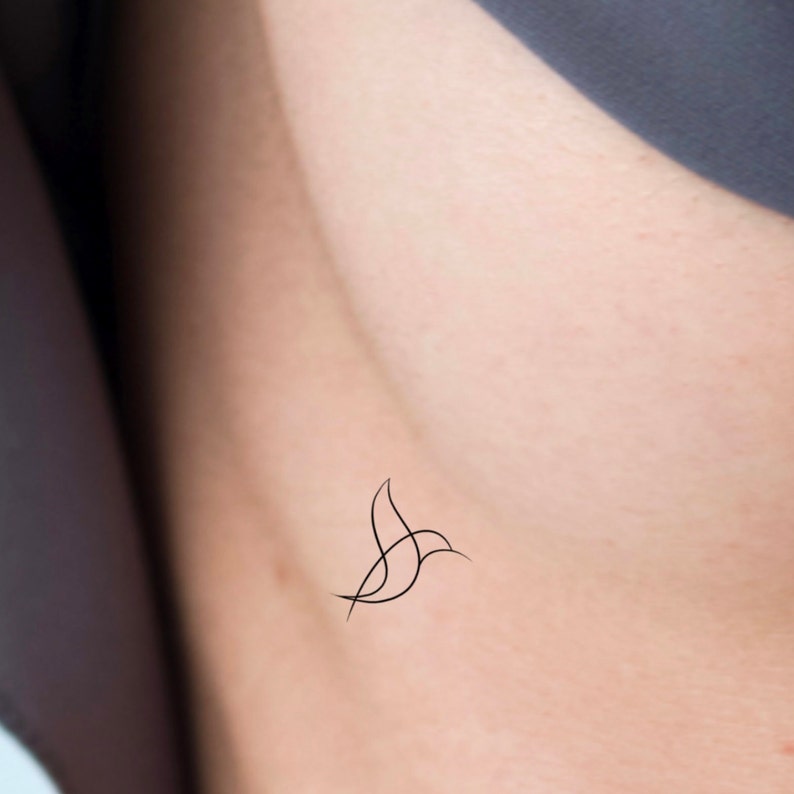 May include: A simple line drawing of a bird tattoo on a person's skin.