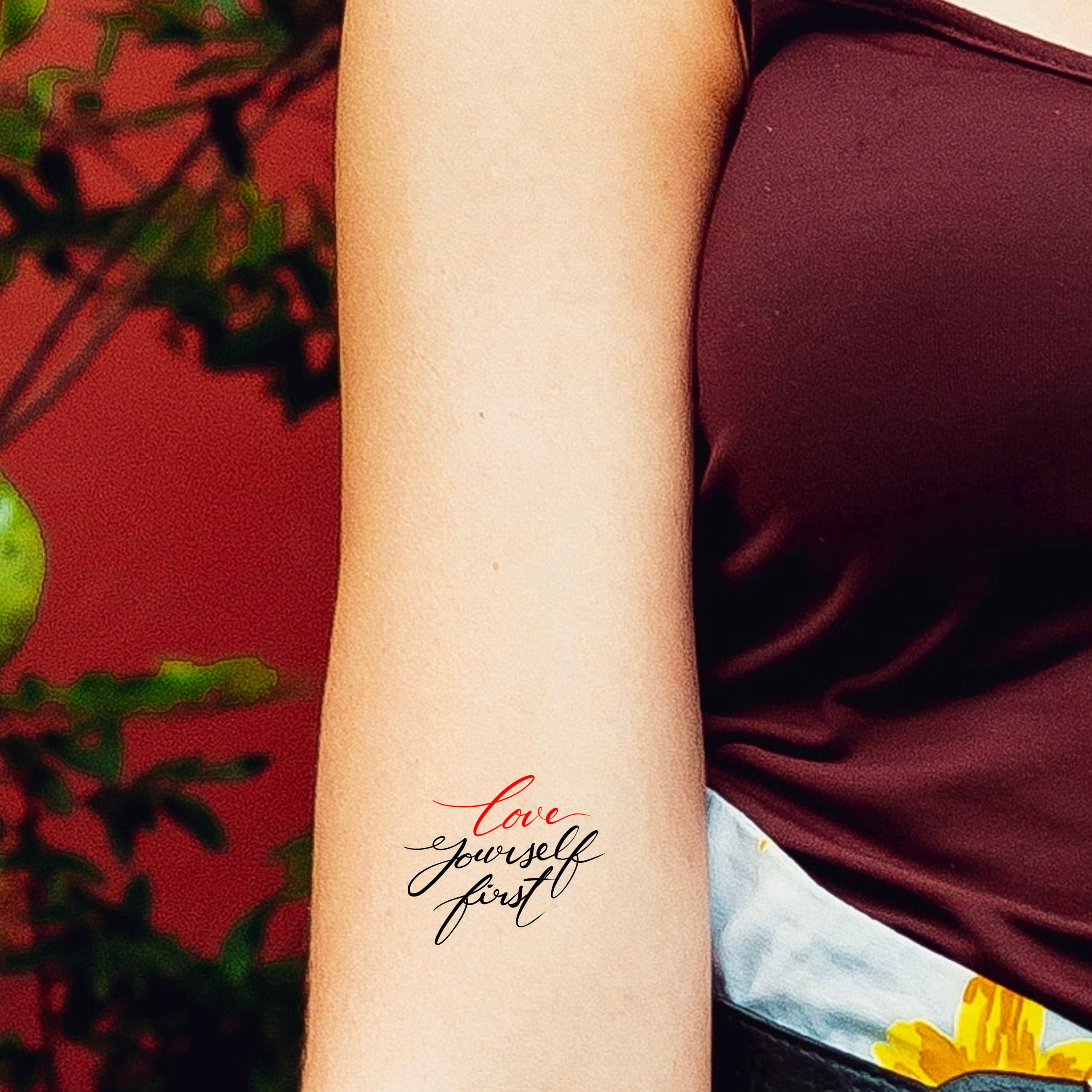Love yourself tattoo on the inner forearm