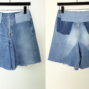 May include: A pair of denim shorts with a patchwork design. The shorts have a high waist and a flared leg. The fabric is a light blue denim with a distressed look.