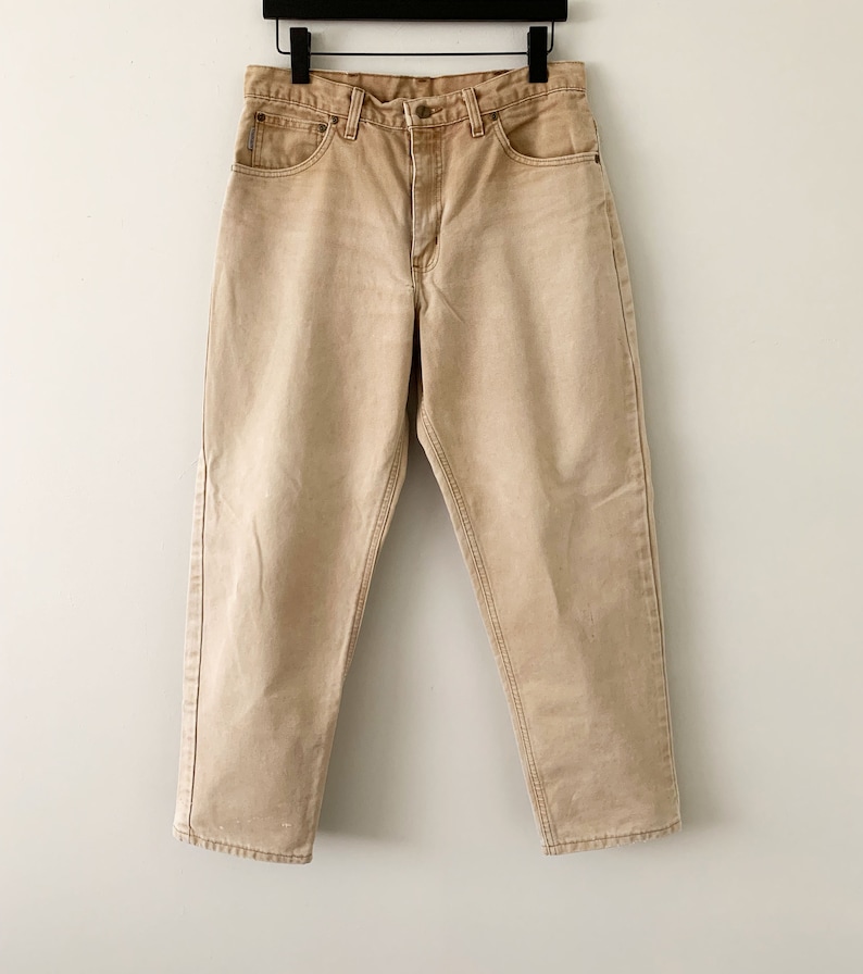 Puede incluir: Un par de pantalones vaqueros de color marr&oacute;n claro, de pierna recta, con un dise&ntilde;o cl&aacute;sico de cinco bolsillos.