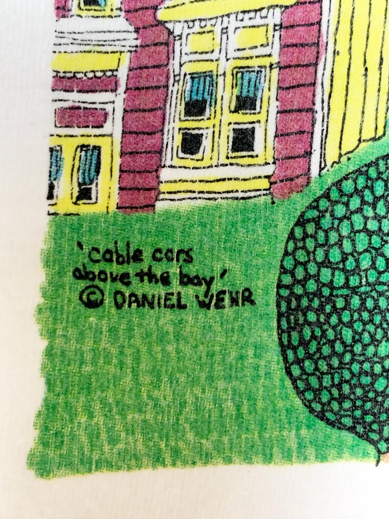 May include: A colorful illustration featuring a house with yellow trim and red walls, with the text "cable cars above the bay" and the artist's name, Daniel Wehr. The image is set against a green lawn.