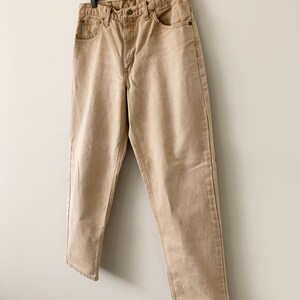 Puede incluir: Un par de pantalones vaqueros de color marr&oacute;n claro, de pierna recta, con cierre de bot&oacute;n y cinco bolsillos.