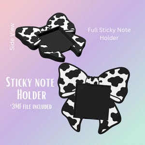 May include: A black and white cow print sticky note holder in a bow shape. The holder has a rectangular space for notes and the text "Sticky Note Holder" and "Full Sticky Note Holder" is displayed.