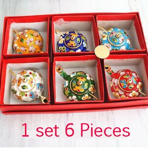 May include: Set of six miniature teapots in a red box. The teapots are decorated with colorful floral patterns and are made of enamel. The teapots are arranged in two rows of three. The box has the text "1 set 6 pieces" printed on the front.
