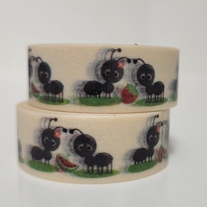 May include: Two rolls of washi tape with a pattern of black ants carrying fruit and watermelon. The tape is cream colored with a green background.