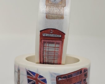 May include: Two rolls of washi tape with London themed designs. The top roll features a red telephone booth and a clock tower. The bottom roll features a double-decker bus, a Union Jack flag, and a clock tower.