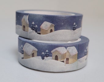 May include: Two rolls of washi tape with a winter village design. The tape features small houses with snow-covered roofs, trees, and a blue night sky.
