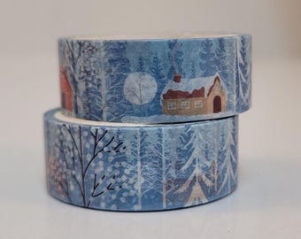 May include: Two rolls of decorative washi tape featuring a winter scene. The tape has a blue background with illustrations of snow-covered trees, houses, and a full moon. The tape is ideal for scrapbooking and crafts.