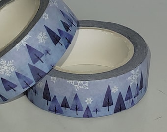 May include: Two rolls of blue washi tape with a winter forest design. The tape features white snowflakes and dark blue trees on a light blue background.