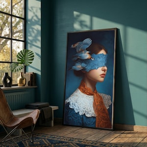 May include: A framed art print featuring a woman with a blue blindfold and birds. The artwork has a dark blue background with a woman wearing a white lace collar and an orange scarf. The birds are blue and white.