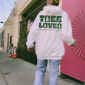 May include: White hoodie with a green graphic that says "Tree Lover" and "Life is better in the woods".