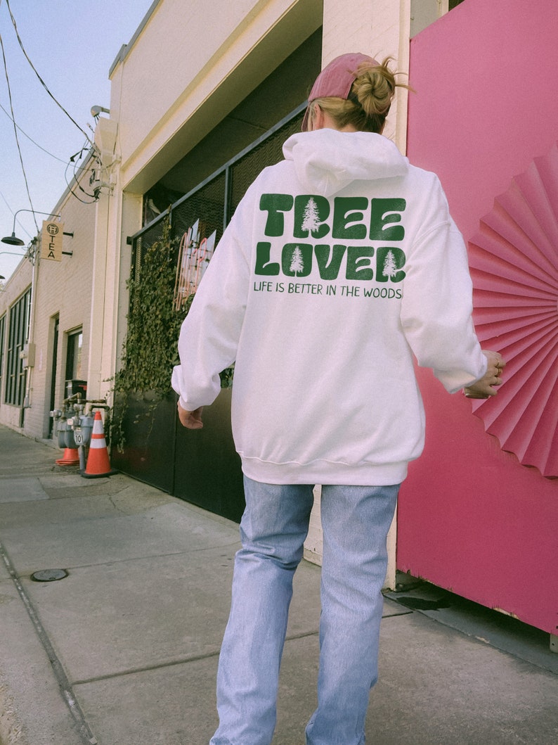 May include: White hoodie with a green graphic that says "Tree Lover" and "Life is better in the woods".