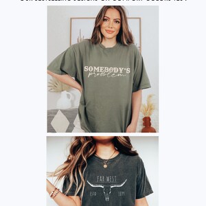 K&ouml;nnte beinhalten: Zwei T-Shirts mit unterschiedlichen Designs. Das erste T-Shirt ist olivgr&uuml;n mit dem Text "Somebody's problem" in cremefarbener Farbe. Das zweite T-Shirt ist dunkelgrau mit einem wei&szlig;en Totenkopf- und Horn-Design und dem Text "Far West Est. 1819".