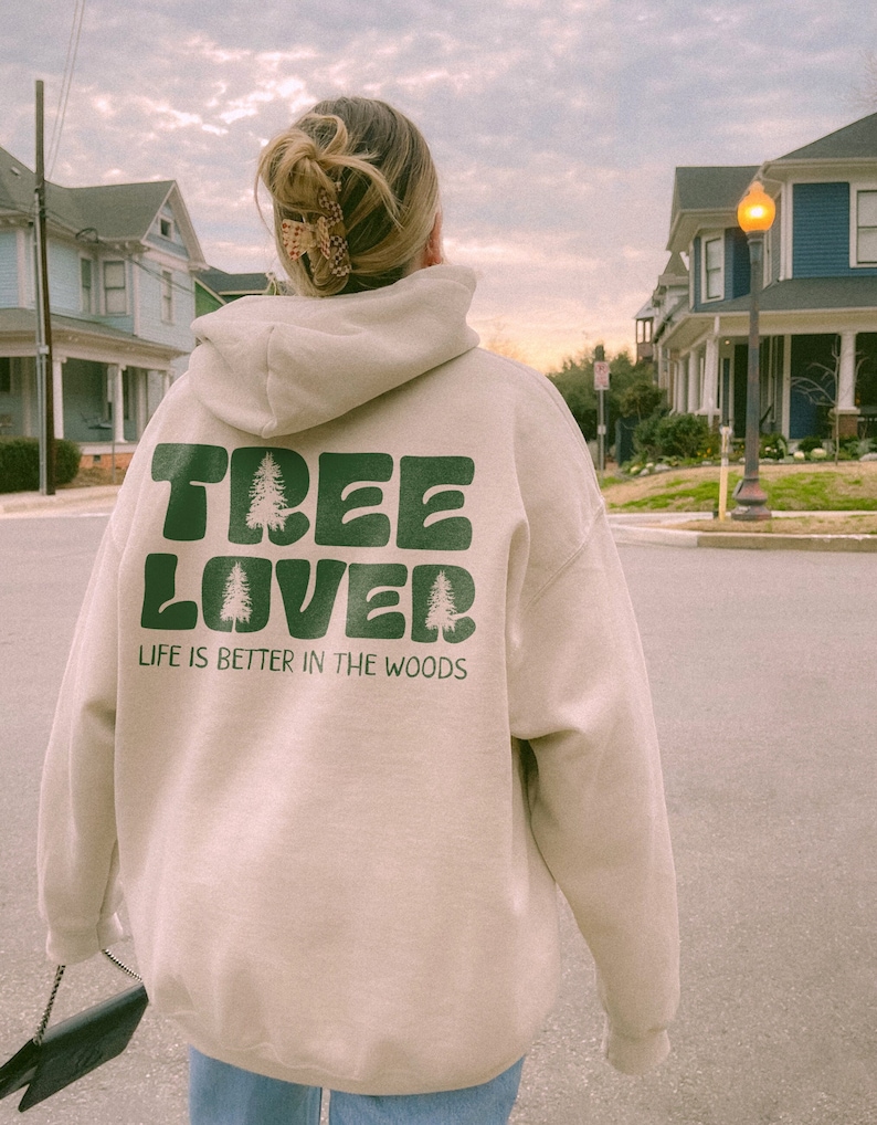 May include: A beige hoodie with a green graphic that says "TREE LOVER" and "LIFE IS BETTER IN THE WOODS".