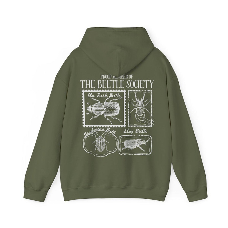 K&ouml;nnte beinhalten: Ein gr&uuml;ner Kapuzenpullover mit einem wei&szlig;en Grafikdruck einer Sammlung von Vintage-Briefmarken mit verschiedenen K&auml;ferarten. Der Text auf den Briefmarken lautet "Elm Bark Beetle", "Stag Beetle" und "Strabosoma Beetle". Der Text &uuml;ber den Briefmarken lautet "Proud member of The Beetle Society".