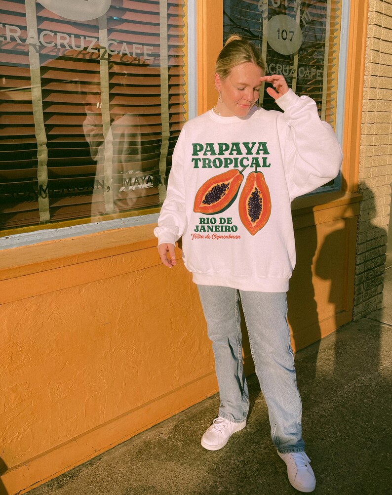 Puede incluir: Sudadera blanca con un gr&aacute;fico de papaya y el texto "Papaya Tropical Rio de Janeiro Feira de Copacabana".