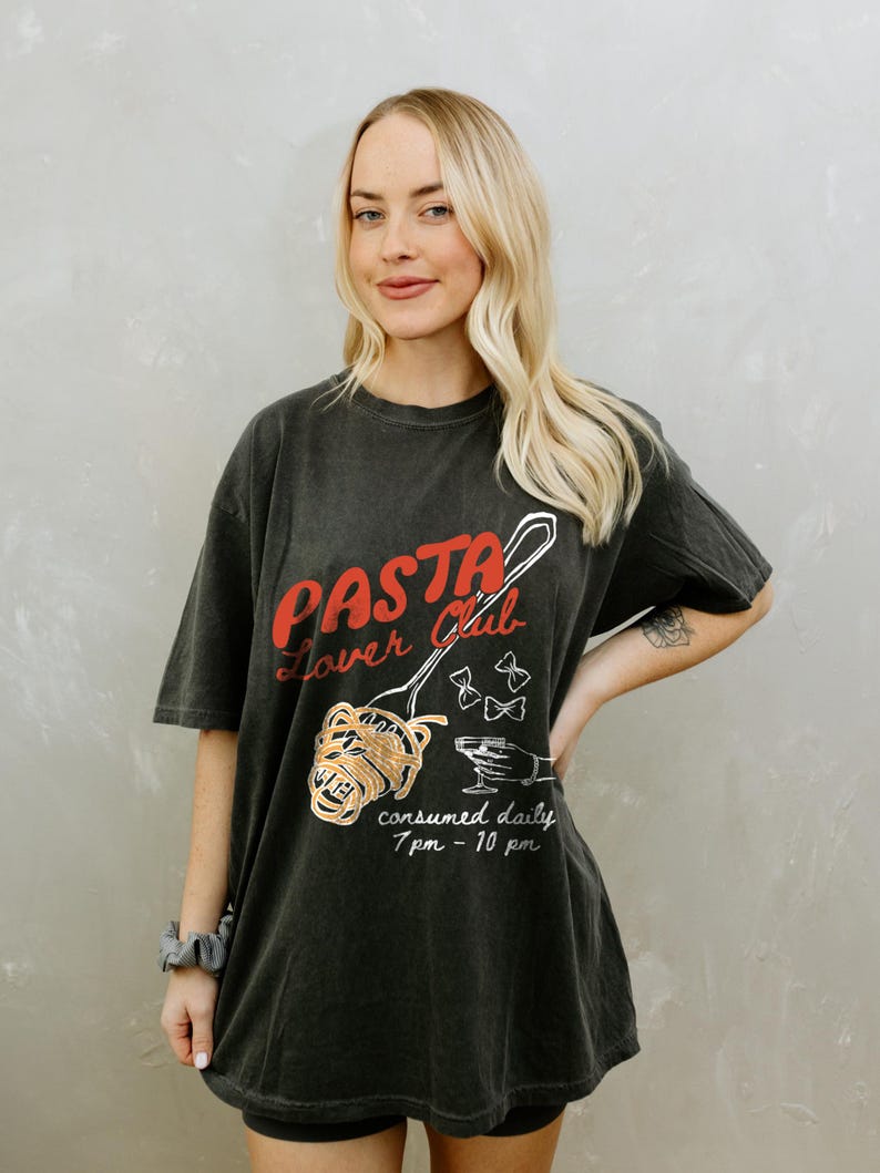 May include: Black oversized t-shirt with a graphic of a spoon holding spaghetti and the text "Pasta Lover Club" and "consumed daily 7pm - 10pm".