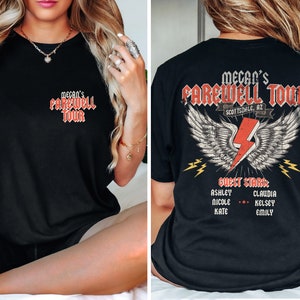 May include: Black t-shirt with a red graphic that says "Megan's Farewell Tour Scottsdale, AZ" with wings and lightning bolts. The back of the shirt lists "Guest Stars" with names Ashley, Nicole, Kate, Claudia, Kelsey, and Emily.