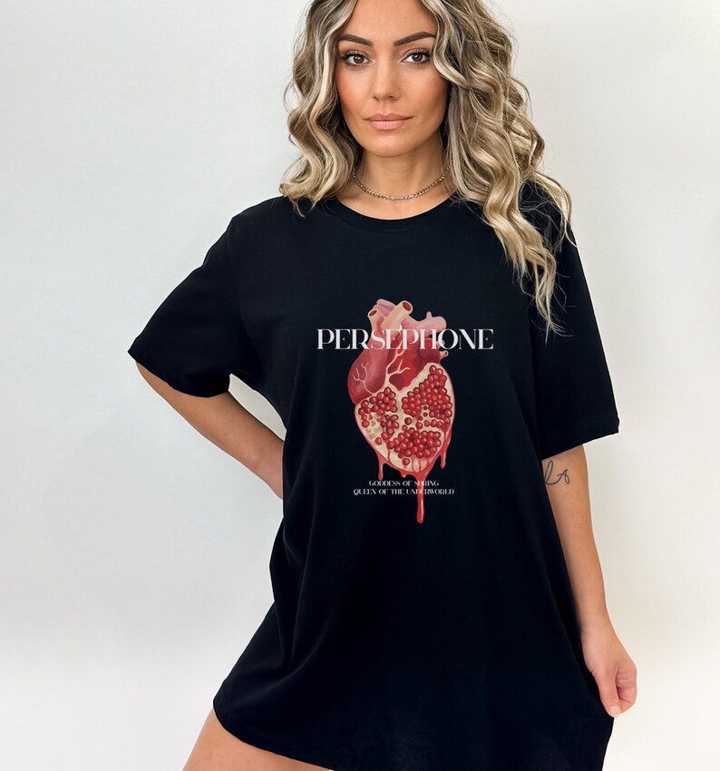 May include: Black t-shirt with a graphic of a red heart made of a pomegranate. The text "PERSEPHONE, GODDESS OF SPRING, QUEEN OF THE UNDERWORLD" is printed below the graphic.