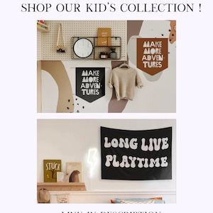 May include: Two black and white wall banners with the text "Make More Adventures" and "Long Live Playtime" in a child's bedroom. The banners are hung on a white pegboard wall with other decorative items.