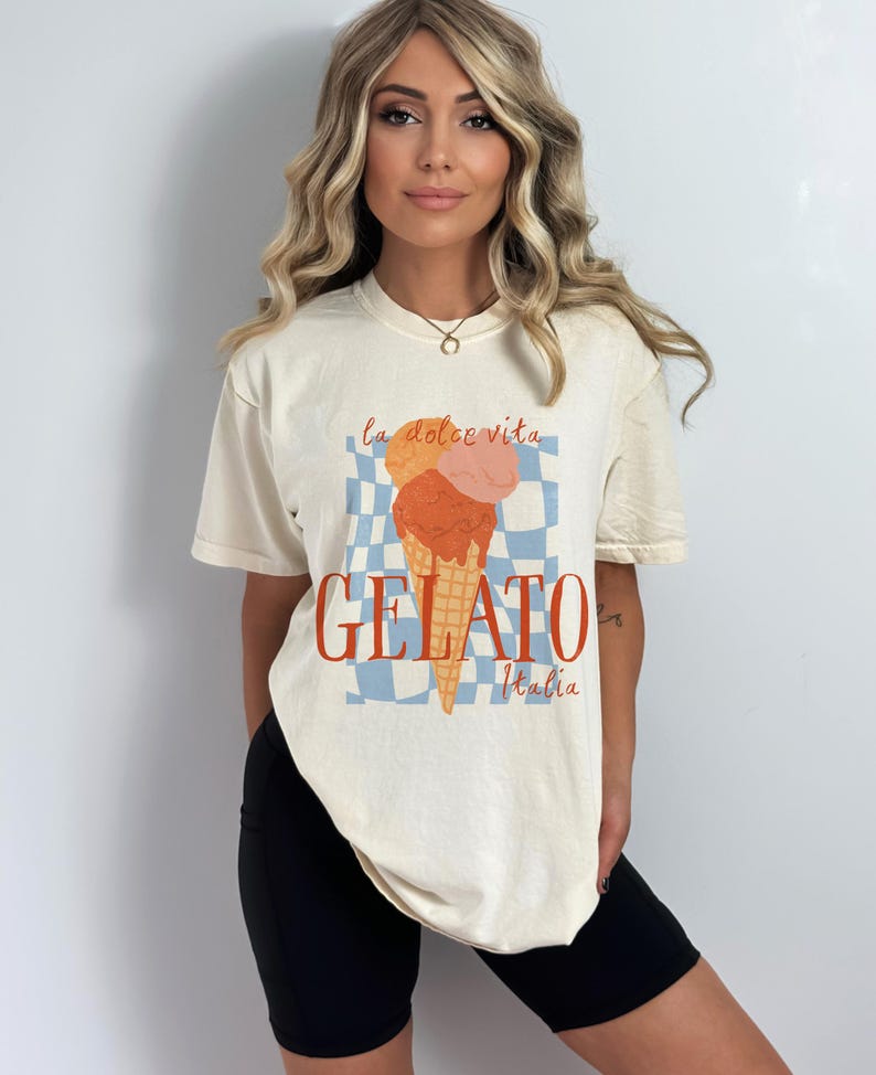 K&ouml;nnte beinhalten: Ein cremefarbenes T-Shirt mit einem Aufdruck eines Eisbechers mit dem Text "la dolce vita GELATO Italia".