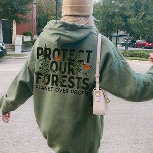 May include: A green hooded sweatshirt with the text "PROTECT OUR FORESTS PLANET OVER PROFIT" printed on the back. The text is surrounded by a graphic of trees and butterflies.