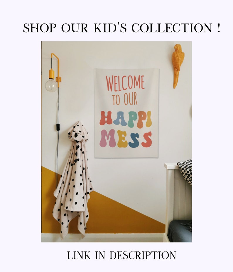 May include: A white canvas wall hanging with the text "Welcome to our Happy Mess" in colourful, bubble-like letters. The wall is painted yellow and white, and there is a black and white polka dot blanket hanging on a hook.