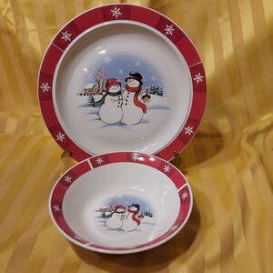 Royal Seasons RN5 Dinnerware.  Red Plaid Rim with snowflakes. Two Snowmen with Red and Green Scarves and red and black hats. Various pieces.