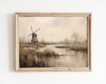 May include: A framed oil painting depicting a windmill in a rural landscape. The windmill is brown and has white blades. The landscape is a muted brown and green with a river in the foreground. The painting is in a light wood frame.