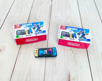 May include: Two Nintendo Switch game boxes featuring Fortnite with a blue and yellow controller and a blue and yellow handheld console. The boxes are red and white with the Nintendo logo. A blue and yellow Nintendo Switch console is also pictured.
