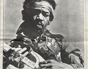 May include: Framed black and white Rolling Stone magazine cover featuring a portrait of Jimi Hendrix playing a guitar. The magazine is dated October 21, 1970, and is set against a white mat.