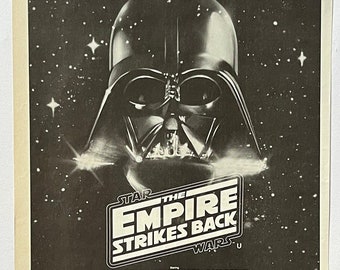 Könnte beinhalten: Ein Schwarzweiß-Plakat, das für den Film "Star Wars: Das Imperium schlägt zurück" wirbt. Das Plakat zeigt Darth Vader vor einem dunklen Weltraumhintergrund mit Sternen. Der Text "The Star Wars Saga Continues" befindet sich oben auf dem Plakat. Der Titel des Films ist in großer Schrift dargestellt, und die Besetzung und die Crew sind darunter aufgeführt. Das Plakat enthält auch Informationen über den Kinostart des Films und wo er gezeigt wird.