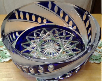 May include: A clear glass bowl with a blue and white swirl design. The bowl has a starburst pattern in the center.