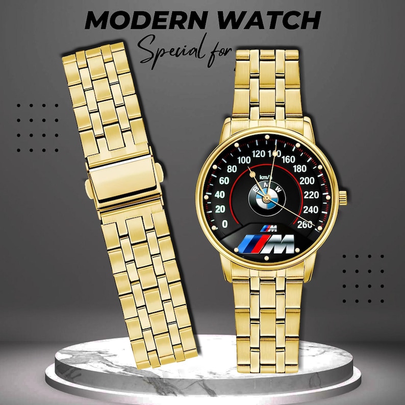 May include: A gold-toned wristwatch with a black speedometer-style face featuring the BMW logo and a matching gold band. The watch face displays numbers up to 260 km/h. The text "MODERN WATCH" and "Special for" are at the top.
