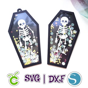 May include: Two black coffin-shaped ornaments with clear plastic windows. Each window contains a white skeleton and colorful glitter. The text "SVG | DXF" is printed below the ornaments.