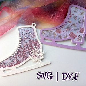 Puede incluir: Dos adornos de patines de hielo blancos con patrones florales. El patín de la izquierda tiene un diseño de copo de nieve. El patín de la derecha es morado. El texto "SVG | DXF" está en la parte inferior de la imagen.