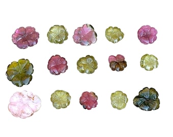 May include: A collection of carved gemstone flowers in various colors, including pink, green, and yellow. The flowers are arranged on a white background, showcasing their intricate details and natural beauty.