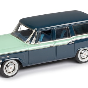 May include: A teal and light green 1957 Studebaker station wagon model car. The car has a chrome bumper and a chrome grille.