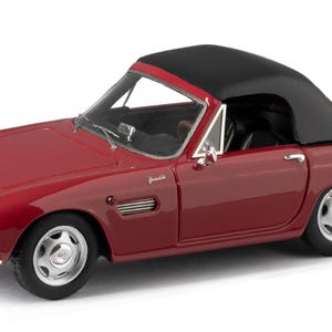 May include: A red convertible car model with a black top. The car has a chrome bumper and wheels.