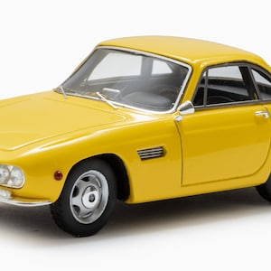 May include: A yellow 1960s Italian sports car with a black interior and a license plate that reads "167769 FE".