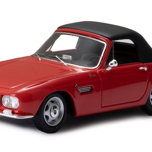 May include: A red convertible car model with a black fabric top. The car has a license plate that reads "29327-UD".