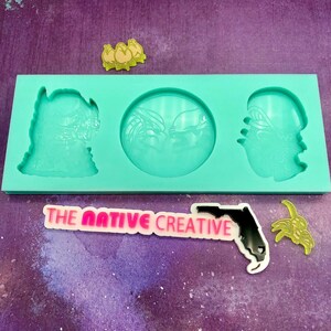May include: A turquoise silicone mold with three cavities. The mold is designed to create three different shapes: a round shape, a tall rectangular shape, and a shorter rectangular shape. The mold is on a purple background with a pink and white logo that says "THE NATIVE CREATIVE" and a black silhouette of the state of Florida.
